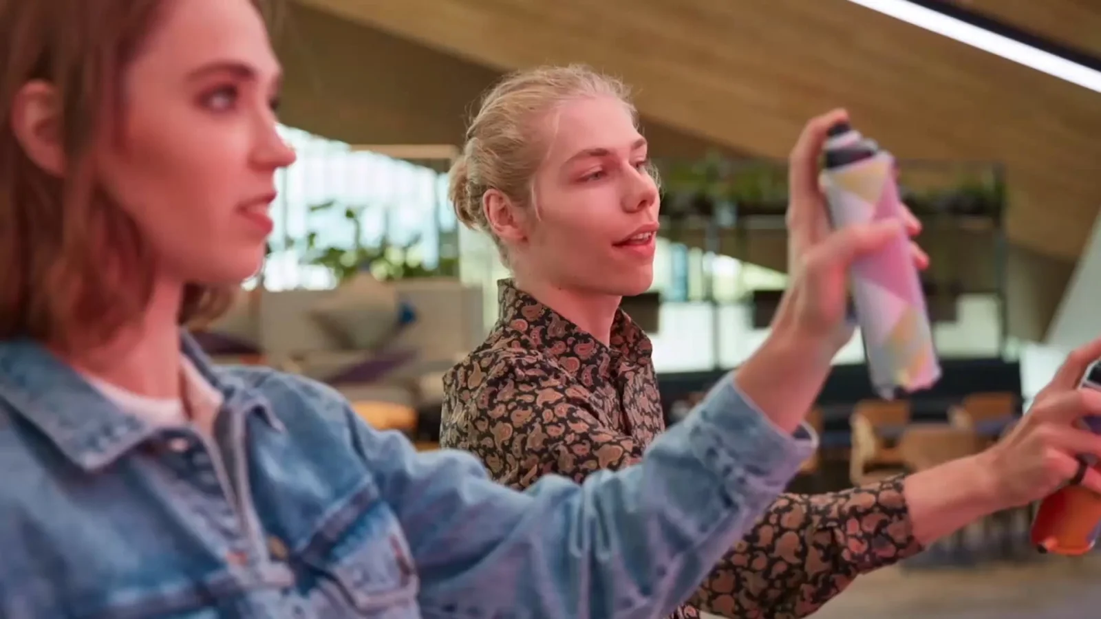 Two guests painting Samsung KX's interactive graffiti wall with custom Samsung-branded geometric spray cans