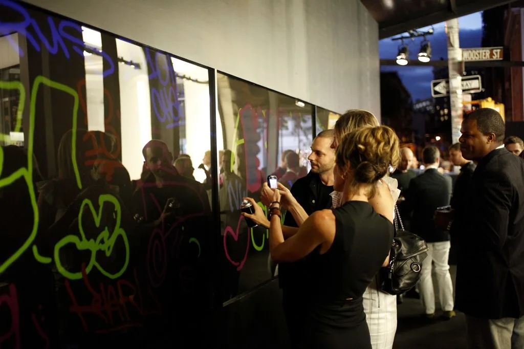 Guests painting the interactive LED graffiti walls at dusk during Fashion's Night Out at the Chanel SoHo flagship, 2010