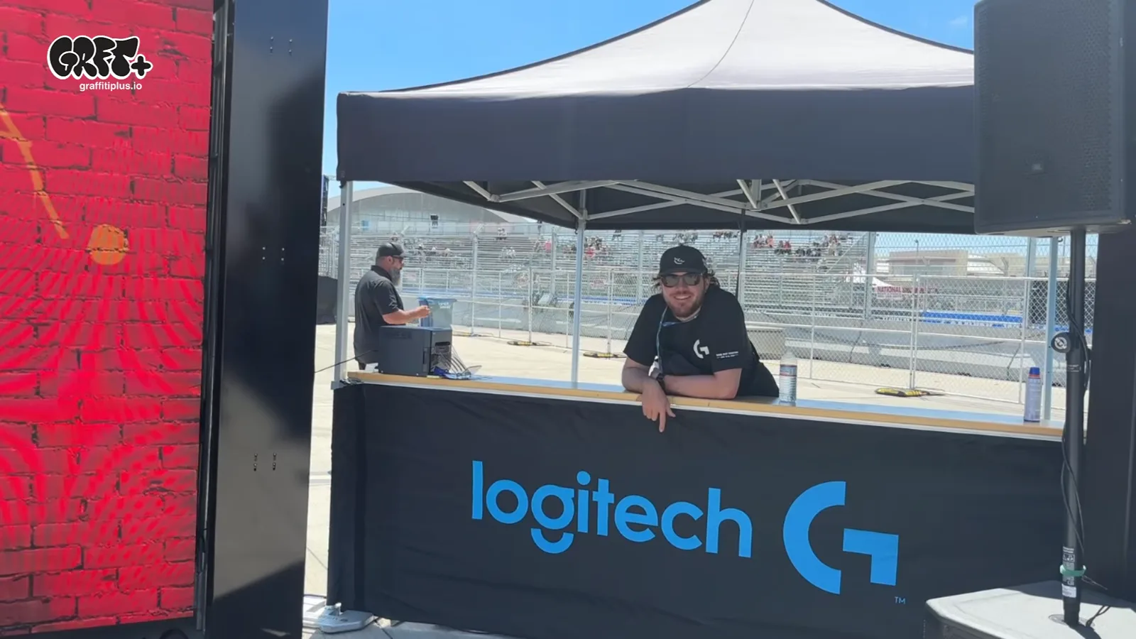 The Logitech-branded Graffiti+ trackside footprint at NASCAR San Diego 2026 — the LED graffiti wall and booth positioned beside the racetrack fencing