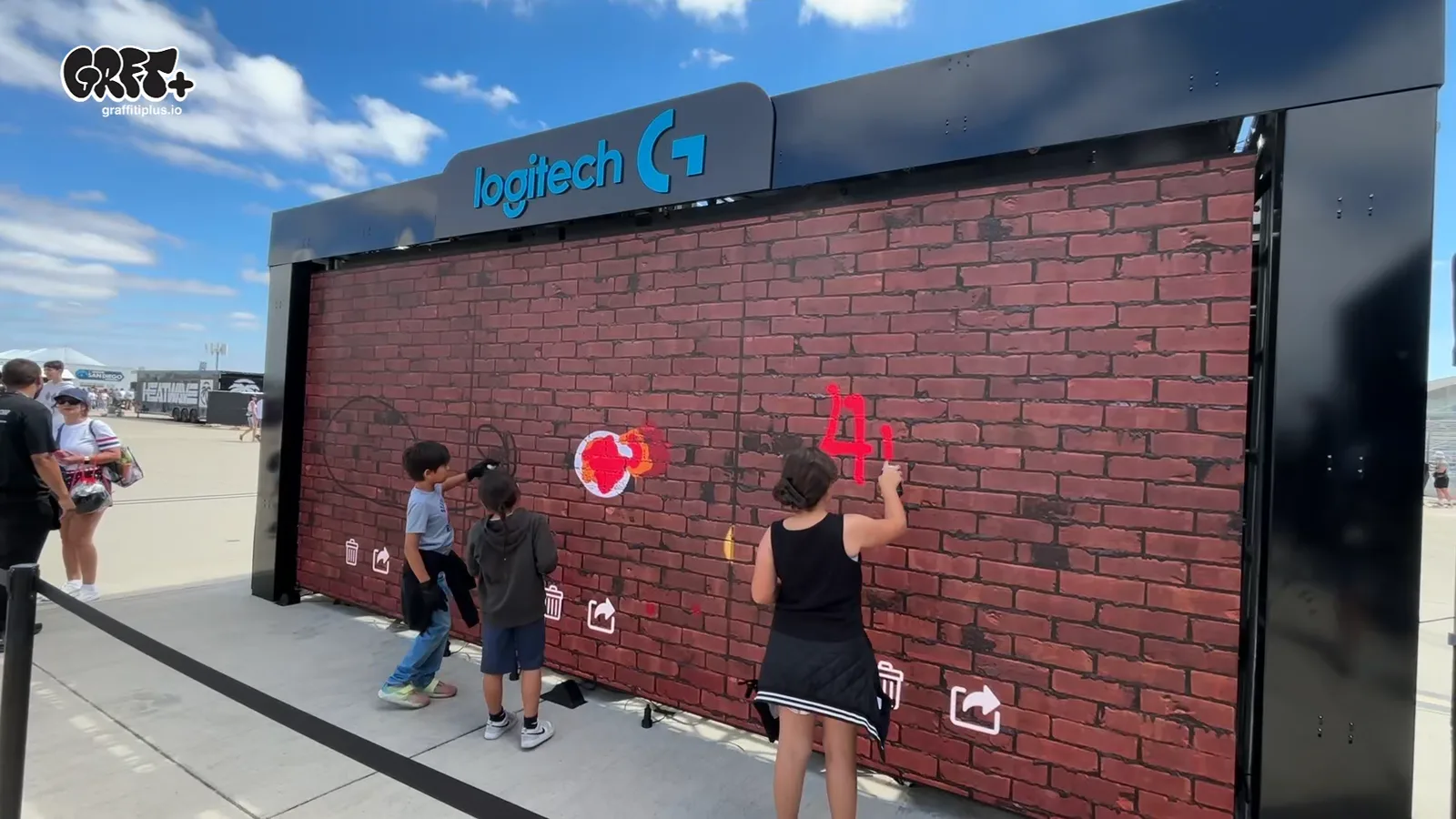 Young fans painting on the Graffiti+ LED graffiti wall at the NASCAR San Diego 2026 Logitech activation
