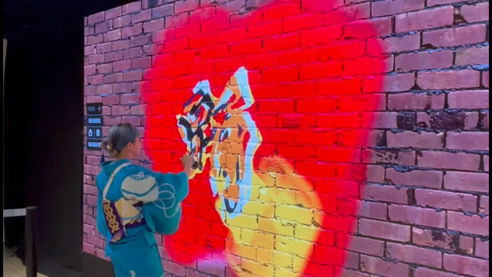 A guest in a yukata painting on the Graffiti+ digital wall at BON CAST., Shibuya Cast, Tokyo