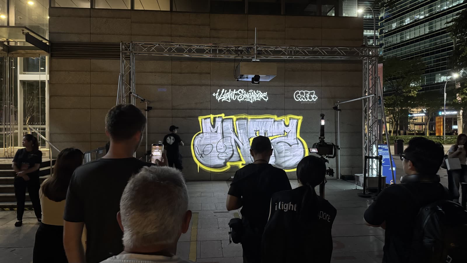 A crowd gathers to watch UNITY painted on the five-metre canvas at i Light Singapore