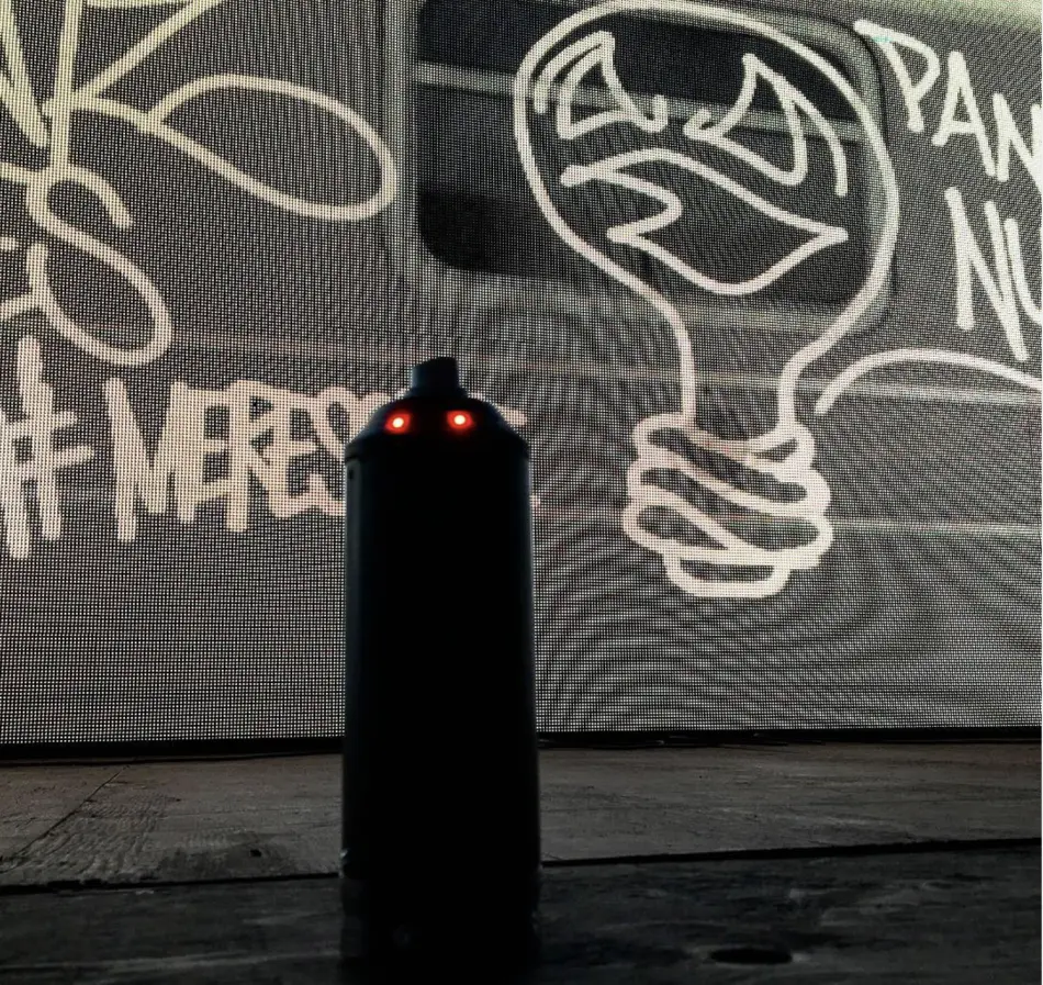 The Graffiti+ spray can with its 3D-tracking markers glowing red, standing in front of the finished subway-car burner on the LED wall